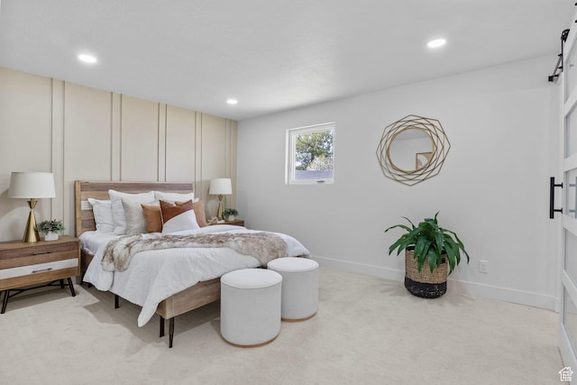 bedroom featuring light carpet, recessed lighting, and a barn door