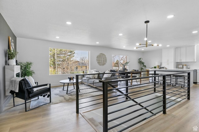 dining space featuring light wood-type flooring, an inviting chandelier, and recessed lighting