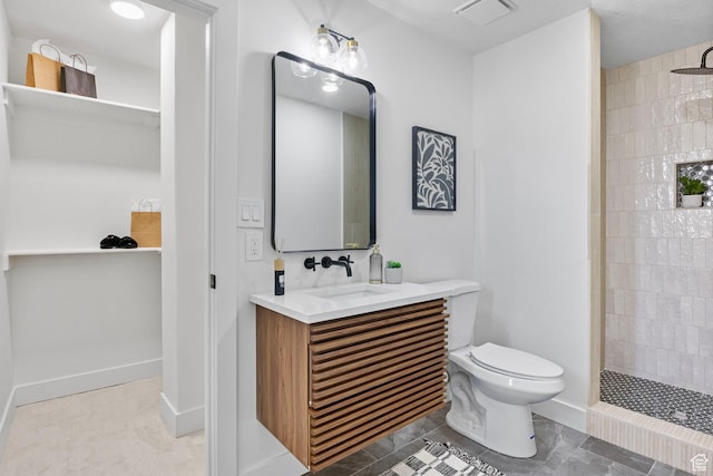 full bath featuring tiled shower, vanity, visible vents, and toilet