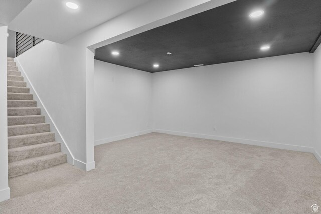 finished basement featuring carpet flooring, baseboards, recessed lighting, and stairway