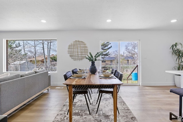 dining area with recessed lighting, baseboards, a textured ceiling, and wood finished floors