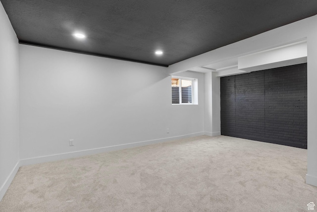 below grade area featuring recessed lighting, carpet, a textured ceiling, and baseboards