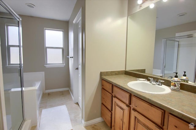 bathroom featuring a stall shower, a garden tub, vanity, and baseboards