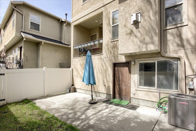 back of property with central AC, fence, a patio, and stucco siding