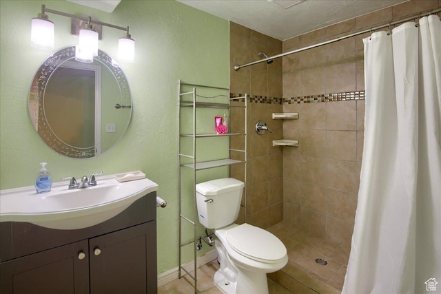 full bath with toilet, vanity, baseboards, and a tile shower
