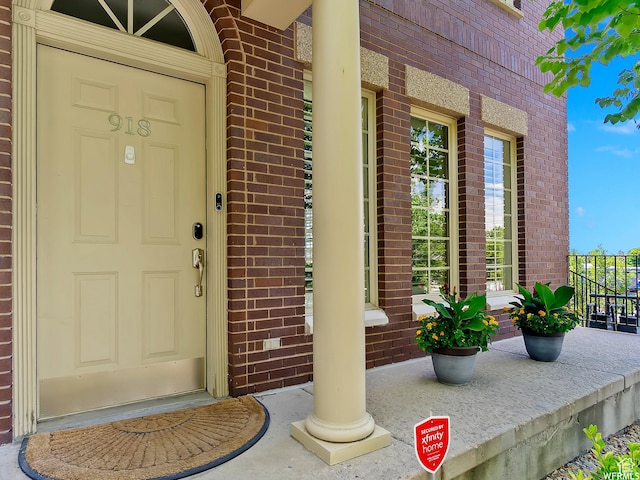property entrance with brick siding and a porch