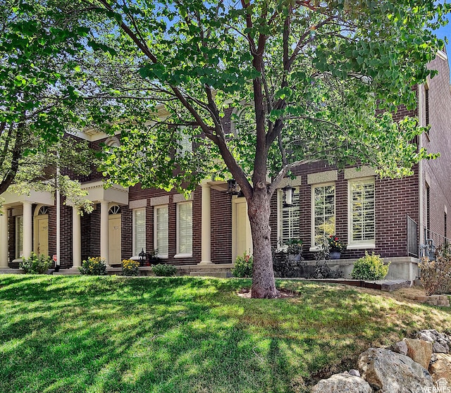 view of front of home featuring a front yard and brick siding