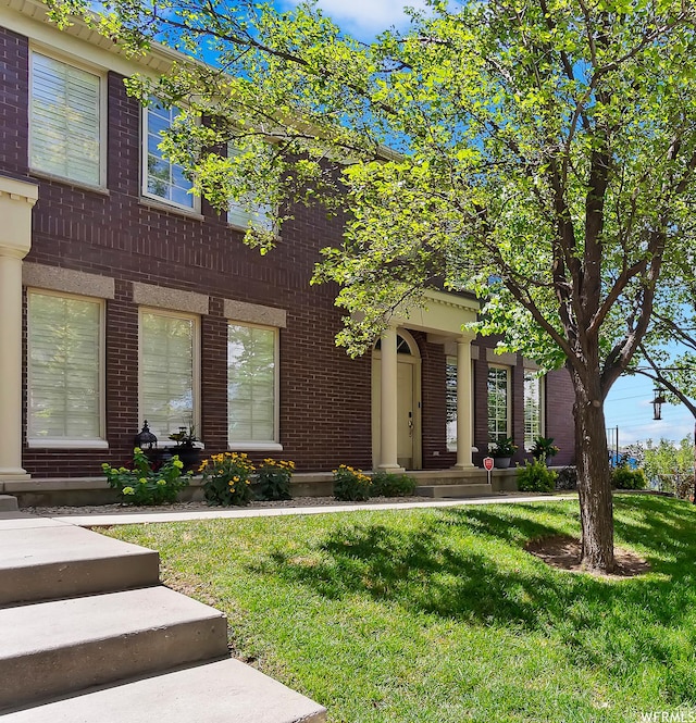 view of front of home featuring a front yard and brick siding