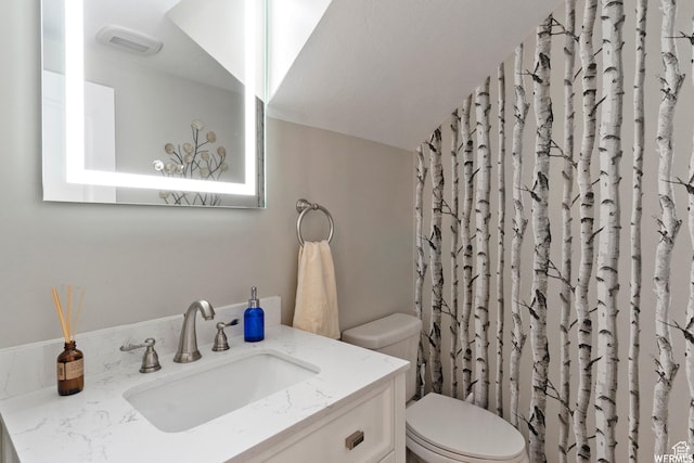 bathroom with vanity, a shower with curtain, visible vents, vaulted ceiling, and toilet
