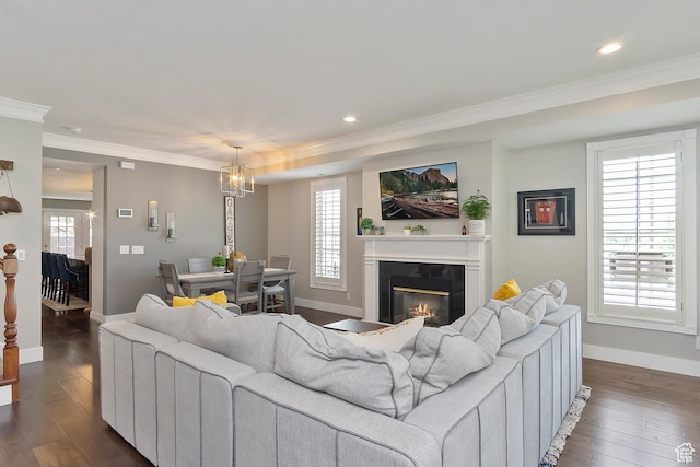 living room featuring baseboards, dark wood-style floors, crown molding, recessed lighting, and a glass covered fireplace