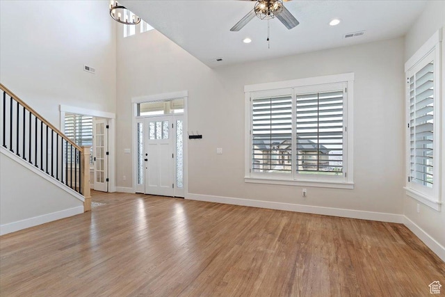 foyer entrance with light wood finished floors, visible vents, and plenty of natural light