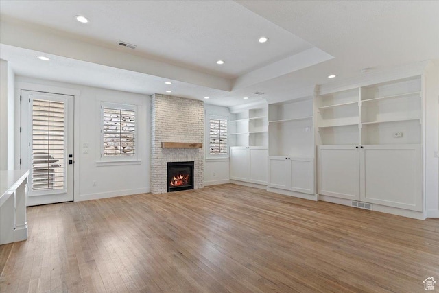 unfurnished living room with light wood-style floors, a fireplace, visible vents, recessed lighting, and baseboards