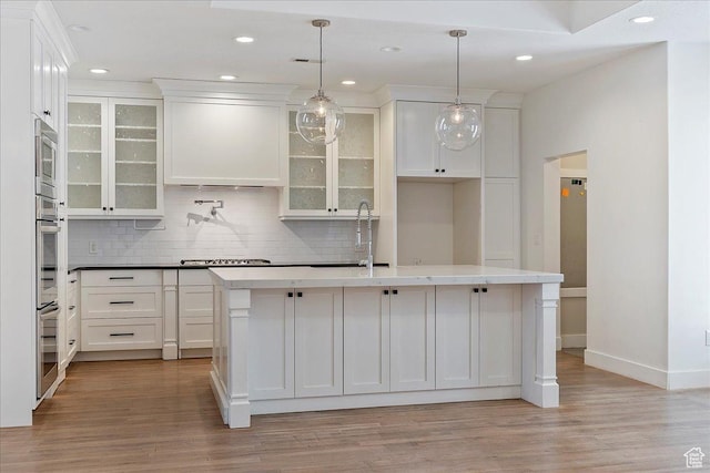 kitchen featuring light wood-style floors, a sink, and white cabinets