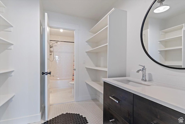 bathroom featuring vanity, baseboards, tile patterned floors,  shower combination, and toilet