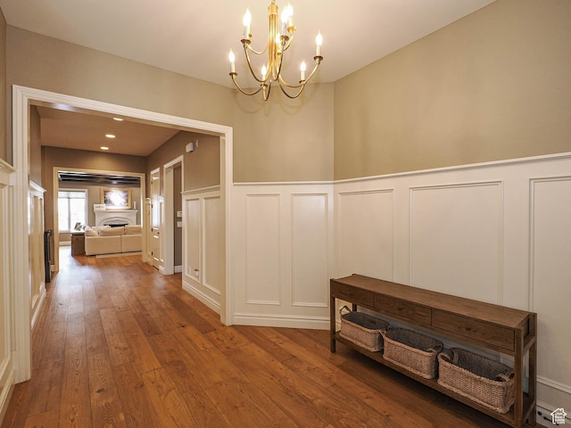 1979 E Olympus Point Dr, Holladay, UT 84117 - hall featuring a chandelier, a decorative wall, wood-type flooring, and wainscoting
