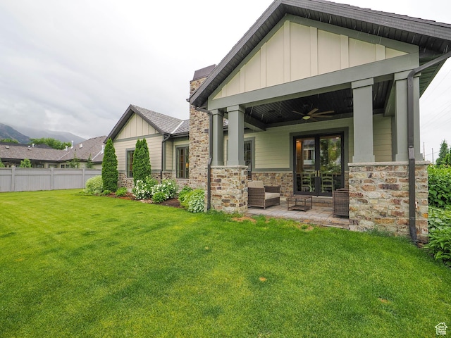 1979 E Olympus Point Dr, Holladay, UT 84117 - back of property featuring board and batten siding, ceiling fan, a yard, a patio, and stone siding