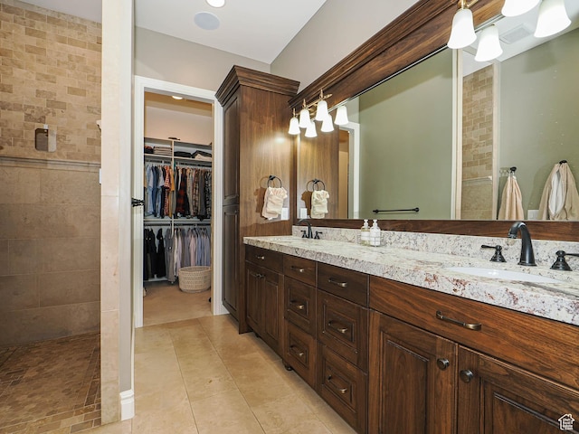 1979 E Olympus Point Dr, Holladay, UT 84117 - bathroom featuring a walk in closet, double vanity, a tile shower, and a sink