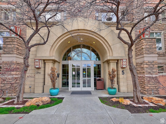 entrance to property featuring french doors and stone siding