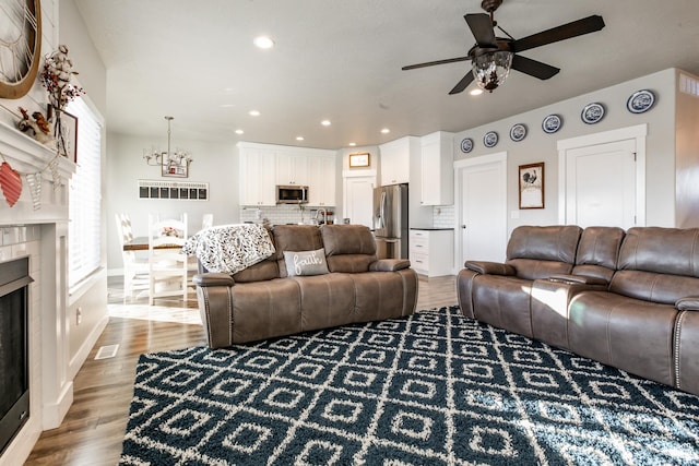 887 S 3050 W, Syracuse, UT 84075 - living room with a fireplace, a ceiling fan, wood finished floors, recessed lighting, and baseboards