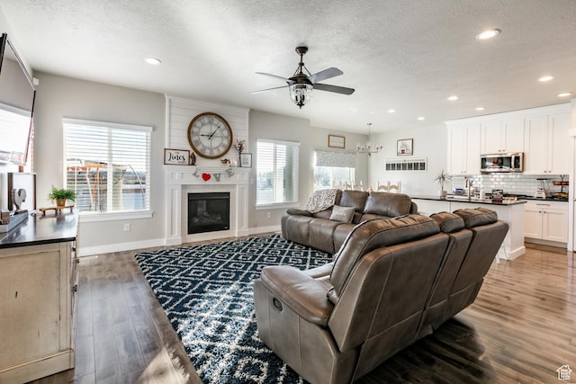887 S 3050 W, Syracuse, UT 84075 - living area with a ceiling fan, wood finished floors, a textured ceiling, baseboards, and recessed lighting
