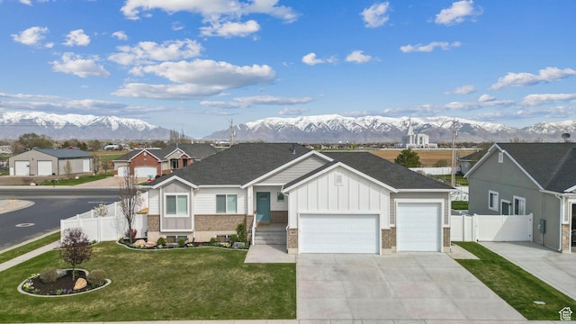 887 S 3050 W, Syracuse, UT 84075 - view of front facade featuring board and batten siding, a mountain view, driveway, and a garage