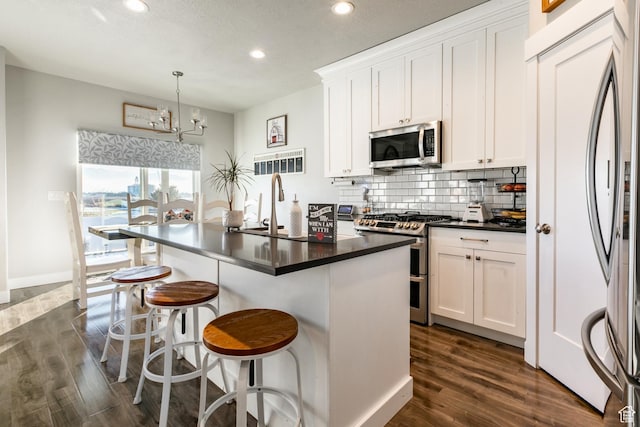 887 S 3050 W, Syracuse, UT 84075 - kitchen with appliances with stainless steel finishes, recessed lighting, dark countertops, dark wood-type flooring, and backsplash