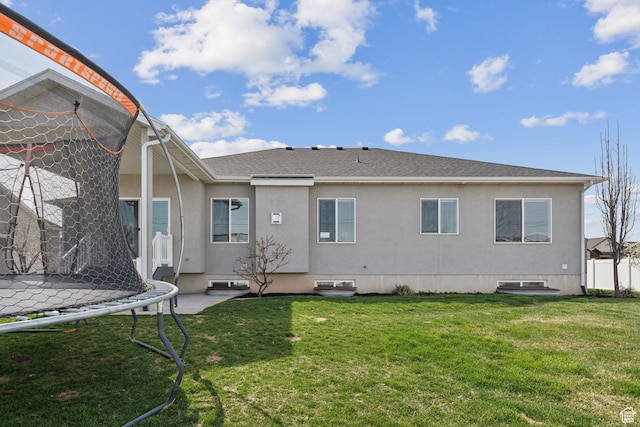 887 S 3050 W, Syracuse, UT 84075 - back of house featuring a trampoline, a lawn, and stucco siding