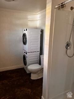 56 E Center St Unit 1, Richfield, UT 84701 - bathroom with toilet, ornamental molding, baseboards, stacked washer and dryer, and a shower