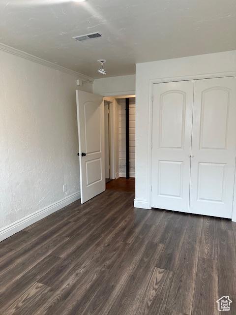 56 E Center St Unit 1, Richfield, UT 84701 - unfurnished bedroom with dark wood-style flooring, crown molding, and a closet