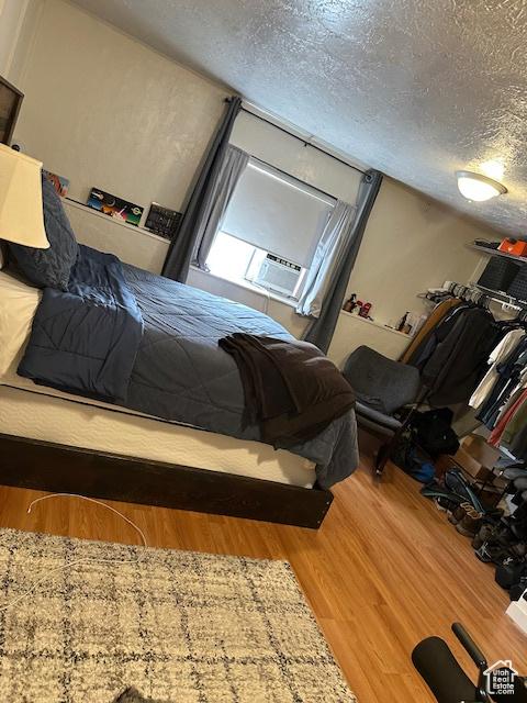 56 E Center St Unit 1, Richfield, UT 84701 - bedroom featuring wood finished floors, a textured ceiling, and cooling unit