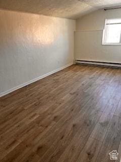 56 E Center St Unit 1, Richfield, UT 84701 - additional living space with a baseboard heating unit, lofted ceiling, baseboards, and dark wood-style floors