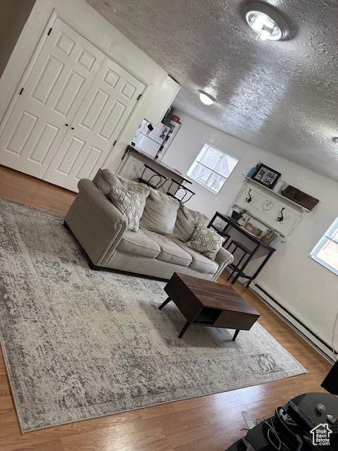 56 E Center St Unit 1, Richfield, UT 84701 - living area featuring wood finished floors, baseboard heating, and a textured ceiling