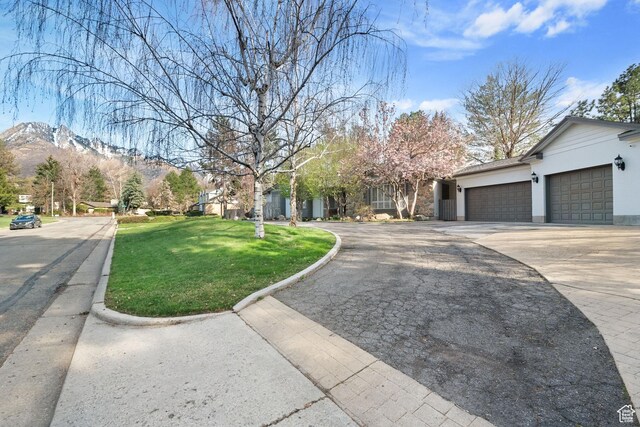 1850 E Cottonwood Club Dr, Holladay, UT 84117 - view of front facade featuring a mountain view, a garage, stucco siding, a front lawn, and driveway