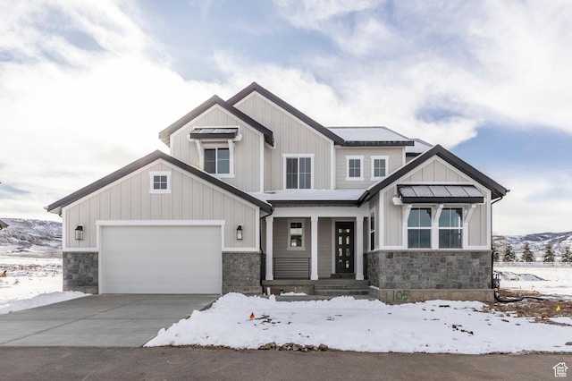 view of front of house featuring driveway, stone siding, board and batten siding, an attached garage, and a porch