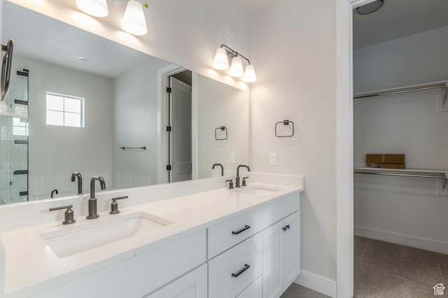 2989 Rock View Dr Unit 105, Francis, UT 84036 - full bathroom featuring a walk in closet, double vanity, baseboards, and a sink
