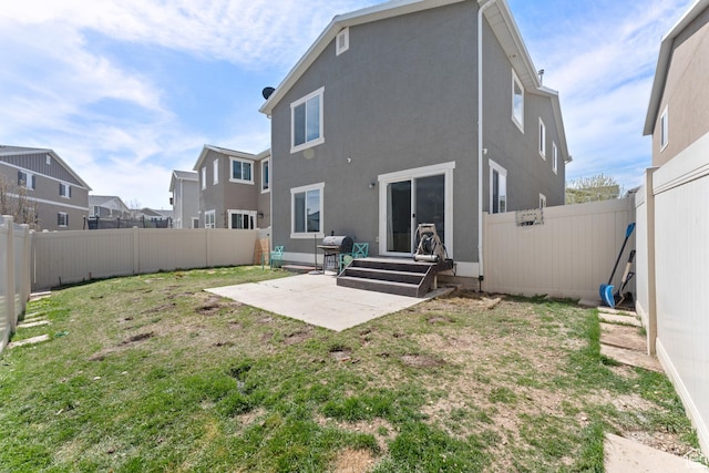 rear view of house featuring a patio, stucco siding, entry steps, and a lawn