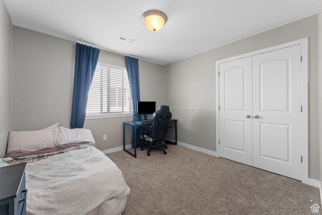 bedroom featuring a closet, visible vents, baseboards, and carpet floors