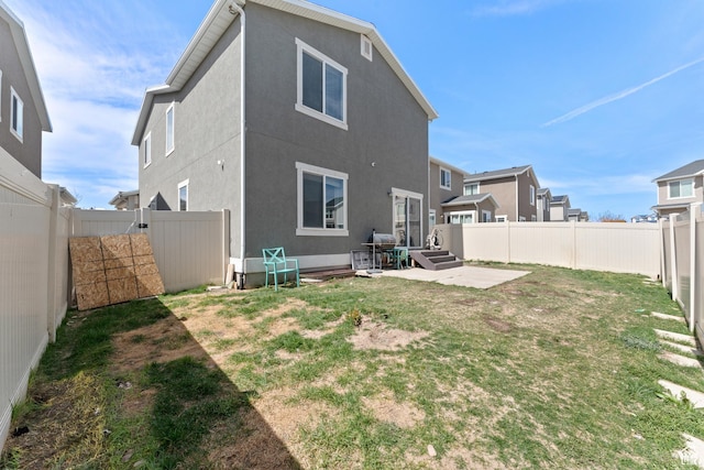 rear view of property with a patio, a yard, and a fenced backyard