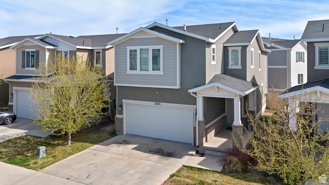 view of front of home featuring a garage, a residential view, driveway, and stucco siding