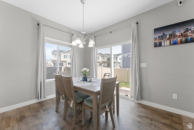 dining room with baseboards, an inviting chandelier, and wood finished floors