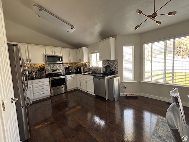 1081 S 900 W, Tooele, UT 84074 - kitchen featuring a sink, dark countertops, vaulted ceiling, stainless steel appliances, and decorative backsplash