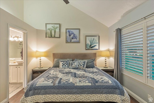 bedroom with ensuite bathroom, baseboards, vaulted ceiling, and wood finished floors