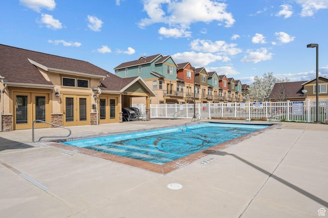 pool featuring a residential view, french doors, fence, and a patio area