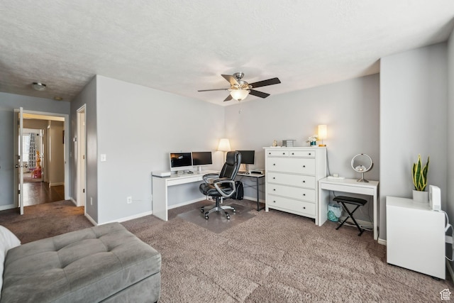 home office featuring carpet flooring, baseboards, a textured ceiling, and ceiling fan