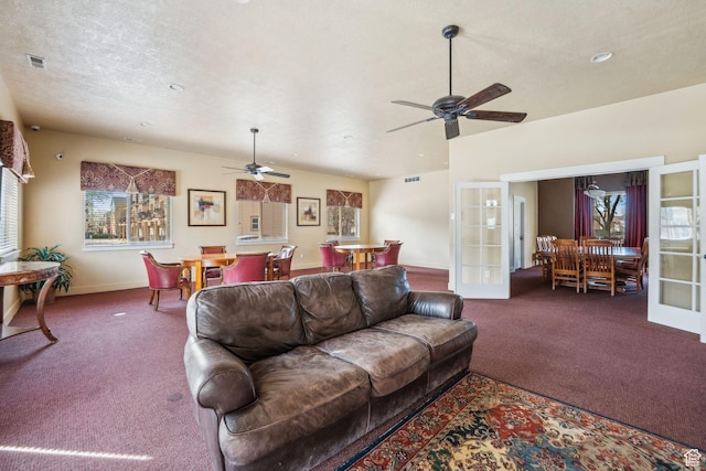 living room featuring a textured ceiling, french doors, ceiling fan, and carpet