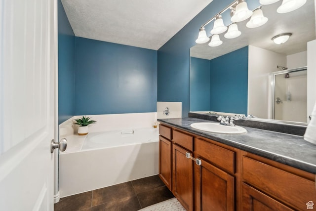 bathroom featuring a garden tub, a shower stall, a textured ceiling, vanity, and tile patterned flooring