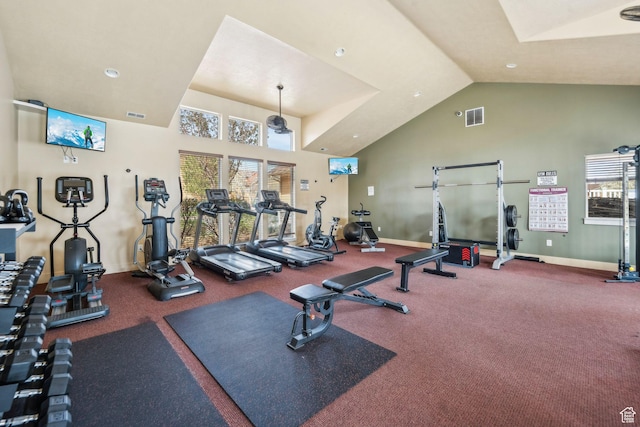 gym with high vaulted ceiling, visible vents, and baseboards