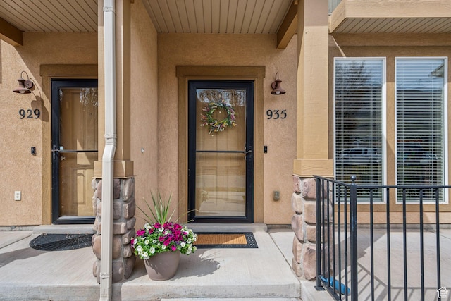 doorway to property featuring stucco siding