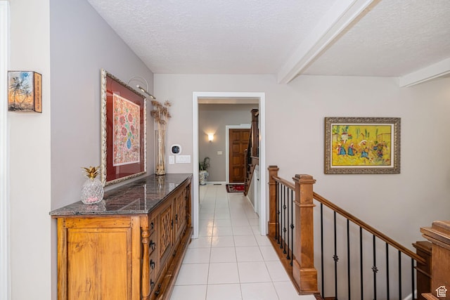 2406 Woodland Dr, Ogden, UT 84403 - hallway featuring beam ceiling, an upstairs landing, light tile patterned flooring, and a textured ceiling