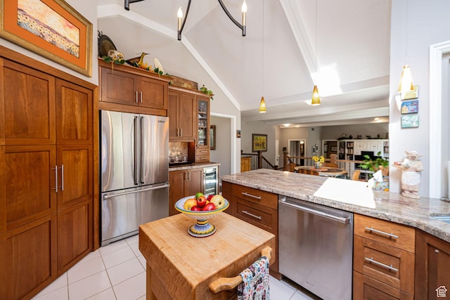 2406 Woodland Dr, Ogden, UT 84403 - kitchen with light tile patterned floors, wine cooler, brown cabinets, lofted ceiling, and stainless steel appliances